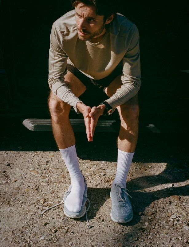 Runner seated on a bench, orthotic trainers