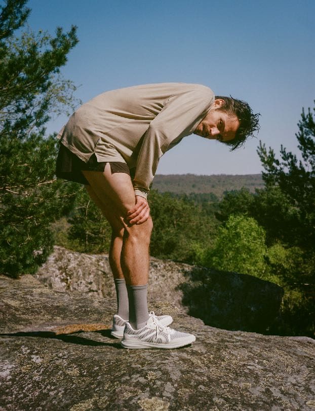 Runner on a rock, hands on knees