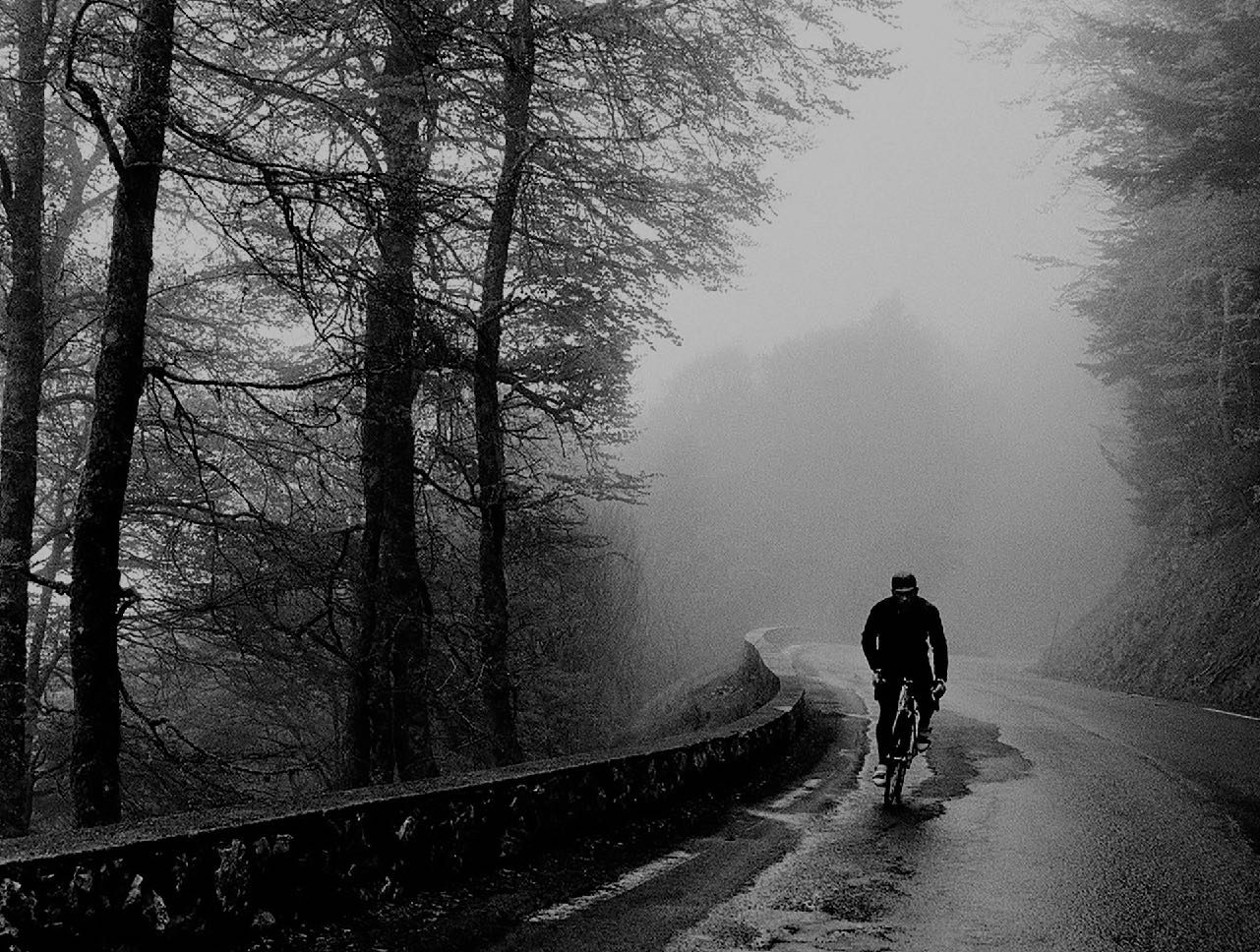 Lone rider on a wet mountain road
