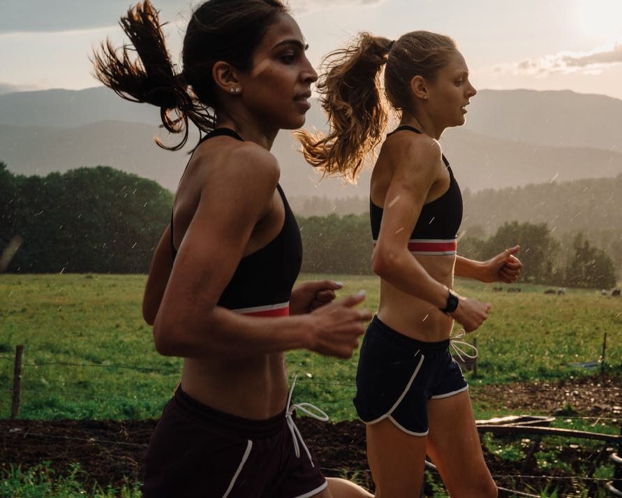 Two runners on a hillside at dawn